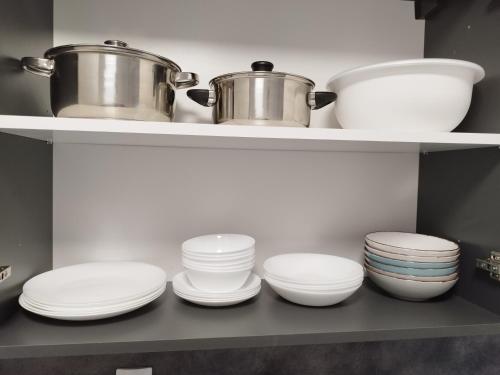 a kitchen with white plates and bowls on shelves at Apartma MB center in Maribor