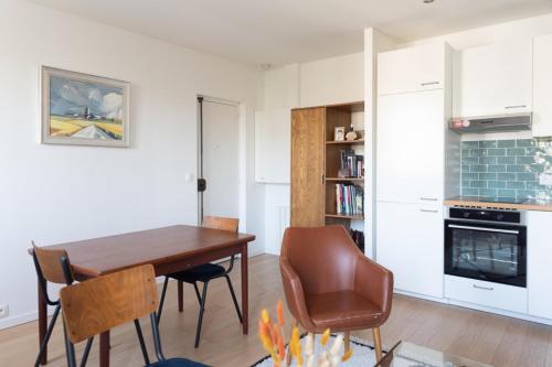 kuchnia i jadalnia z drewnianym stołem i krzesłami w obiekcie Charming 35m near Paris w mieście Saint-Ouen