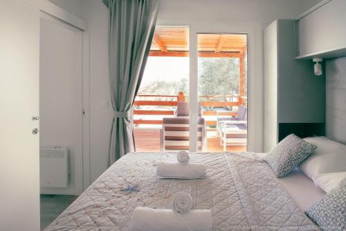 a bedroom with a large bed with towels on it at Mobilheim Maja in Nin
