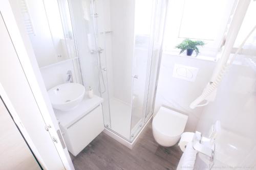 a white bathroom with a toilet and a sink at Mobilheim Maja in Nin