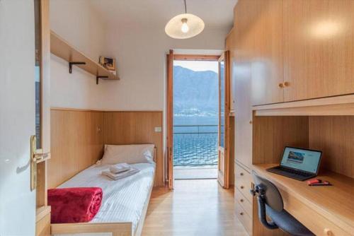 1 dormitorio con 1 cama y escritorio con ordenador portátil en Paolo's Home - overlooking the Lake en Colonno