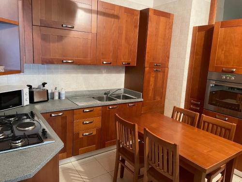a kitchen with wooden cabinets and a wooden table at Apartment Donatello in Mestre