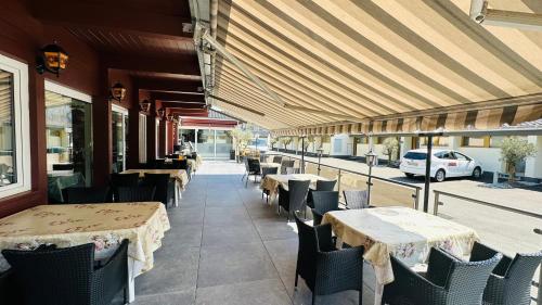 un ristorante con tavoli e sedie e un'auto sulla strada di The River Village a Interlaken
