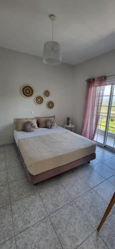 1 dormitorio con 1 cama en una habitación con ventana en Villa Michalis en Katalagárion