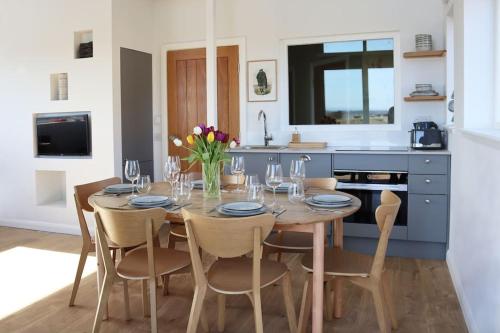 a kitchen with a table and chairs with wine glasses at Eco-Lodge by Golf Course in Colinsburgh