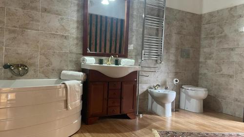 a bathroom with a sink and a tub and a toilet at Doctor House standard, suites & luxury rooms in Enna
