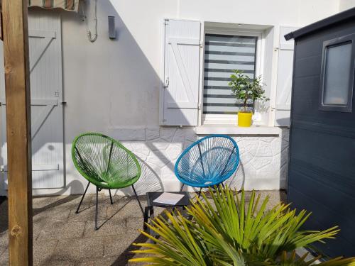 2 chaises assises sur une terrasse à côté d'un bâtiment dans l'établissement Maison location Saint Brévin l'Océan, à Saint-Brévin-les-Pins