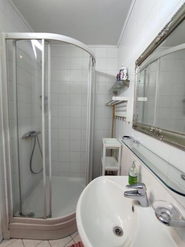 a white bathroom with a shower and a sink at Cozy Dream Apartment in Vilnius