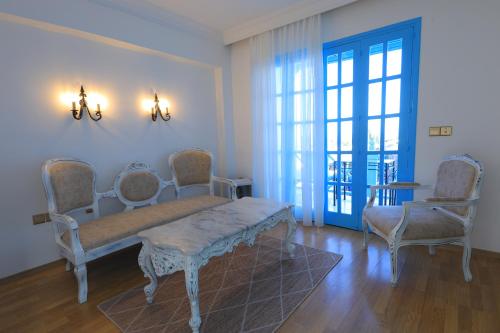 uma sala de estar com cadeiras, um sofá e uma mesa em Bellapais Abbey Boutique Hotel em Kyrenia
