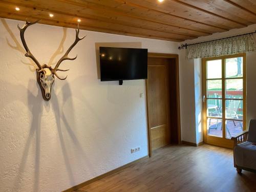 a room with a mounted deer head on a wall at Ferienwohnung Jagdhäusl in Bernau am Chiemsee