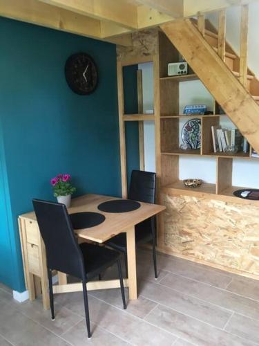 une table à manger avec des chaises et une horloge murale dans l'établissement Appartement avec jardin privé Gréoux les Bains au bord du Verdon, à Gréoux-les-Bains