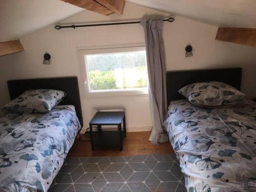 een slaapkamer met twee bedden en een raam bij Appartement avec jardin privé Gréoux les Bains au bord du Verdon in Gréoux-les-Bains