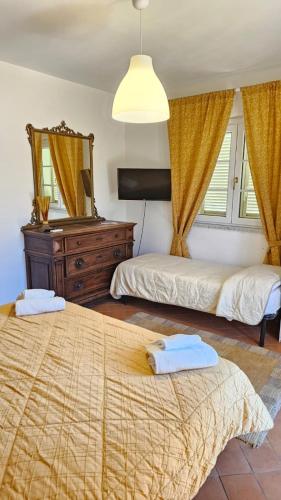 a bedroom with two beds and a mirror at B&B Luna Nuova in Sarzana