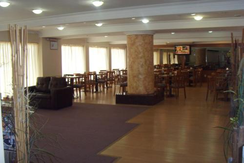 una grande stanza con tavoli e sedie di Hotel Embajador a Rosario