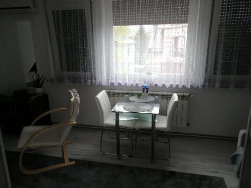 mesa y sillas en una habitación con ventana en Apartament Skawina, en Skawina