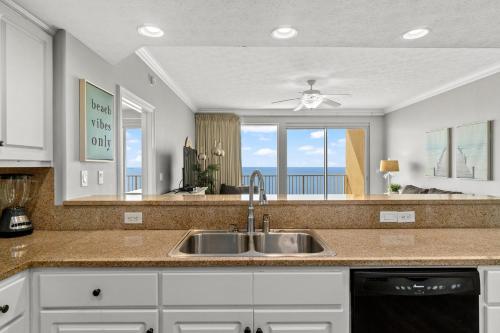 a kitchen with a sink and a view of the ocean at Treasure Island 2306 in Panama City Beach
