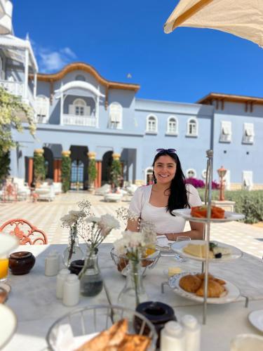 a woman sitting at a table with food on it at Mangroovy Seafront condo - Great Kite Surfing in Hurghada