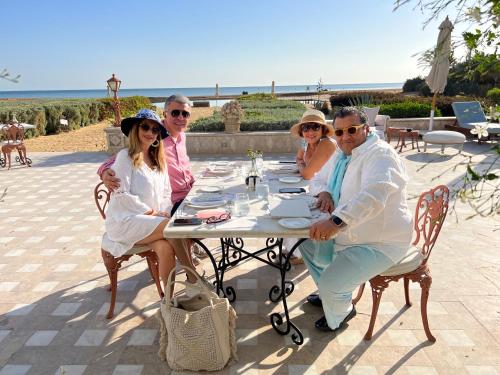 a group of people sitting at a table near the beach at Mangroovy Seafront condo - Great Kite Surfing in Hurghada