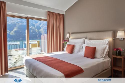 a bedroom with a large bed and a large window at Parco San Marco Lifestyle Beach Resort in Porlezza