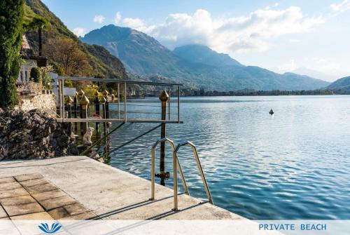a group of people standing on a dock on a lake at Parco San Marco Lifestyle Beach Resort in Porlezza