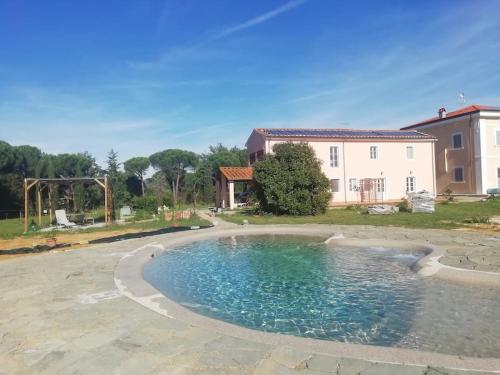 una piscina en un patio con una casa al fondo en Villa Donnola: casa Rosmarino, en Fucecchio