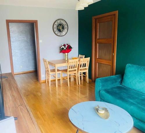 ein Wohnzimmer mit einem blauen Sofa und einem Tisch in der Unterkunft Przestronny apartament in Giżycko