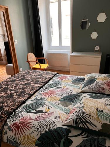- une chambre avec un lit et une couette colorée dans l'établissement Nid douillet T2 wifi centre historique 3 étoiles, à La Rochelle