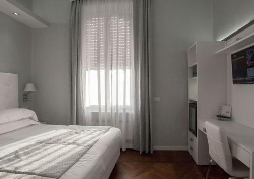 a white bedroom with a bed and a window at Relais Villa Coppedè in Rome