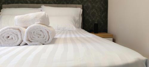 a white bed with towels on top of it at Apartment Denis in Krk