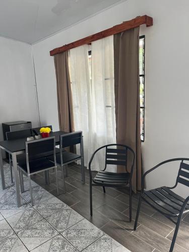 a dining room with chairs and a table and a window at Buganvilla No 4 in Quepos