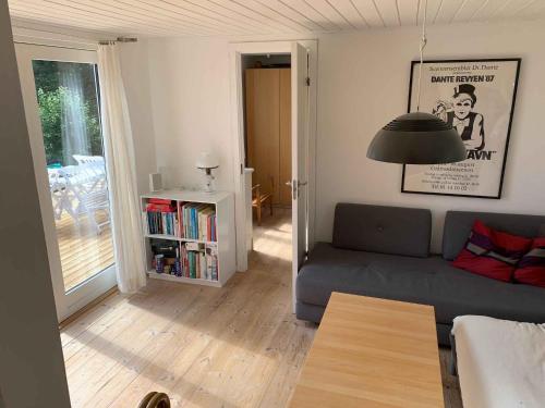 een woonkamer met een bank en een boekenplank bij Traditional Danish Summer House in Hornslet