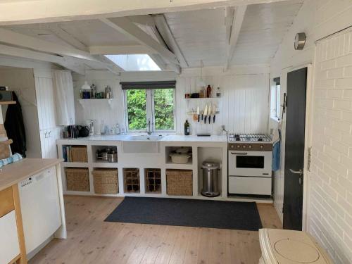 een keuken met witte kasten en een fornuis met oven bij Traditional Danish Summer House in Hornslet