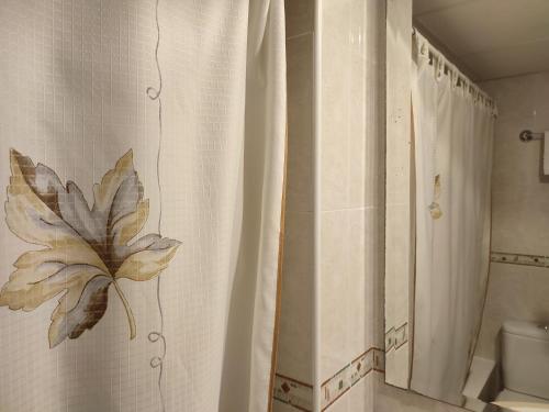 a bathroom with a shower curtain with a leaf on it at Apartamentos Casa Modesto in Escalona