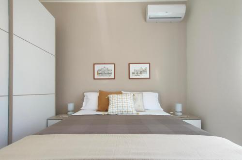 een slaapkamer met een groot bed met 2 kussens bij Ciauru i mari - Elegante appartamento Ortigia in Siracusa