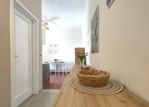 een kamer met een houten tafel met een kom erop bij Ciauru i mari - Elegante appartamento Ortigia in Siracusa