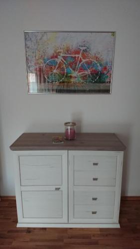 a white dresser with a painting on the wall at Apartment Ferienwohnung Vogt in Sinzheim