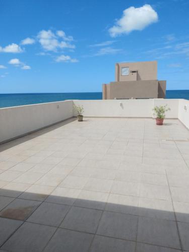 a view of a patio with the ocean in the background at Pousada Bella Bombinhas - Pé na areia in Bombinhas