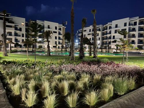 un parc avec des palmiers et des plantes devant les bâtiments dans l'établissement Luxury Apartment with Pool, à Martil