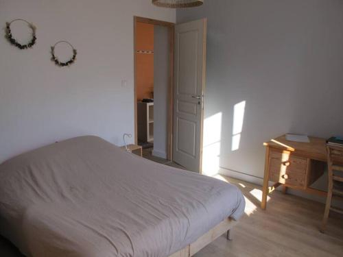 a bedroom with a bed and a table and a door at POLIGNY : appartement refait à neuf ! in Poligny
