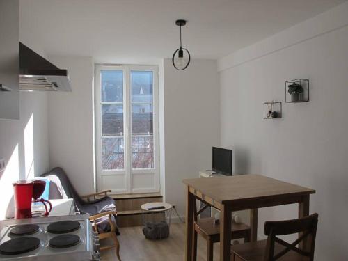 a kitchen with a stove and a table and a window at POLIGNY : appartement refait à neuf ! in Poligny