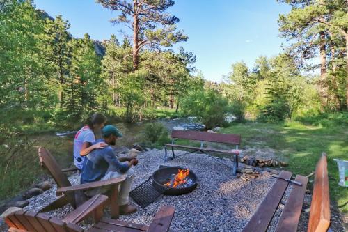 two people sitting around a fire pit at Castle Mountain Lodge in Estes Park