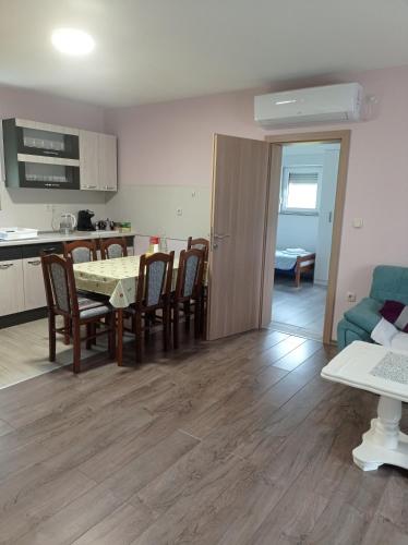 a kitchen and a living room with a table and chairs at Casa Del Pellegrino M&A - Ostojići in Međugorje