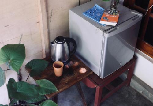 Kingsley Place في ديكويلا تين: وعاء القهوة على طاولة بجوار ثلاجة