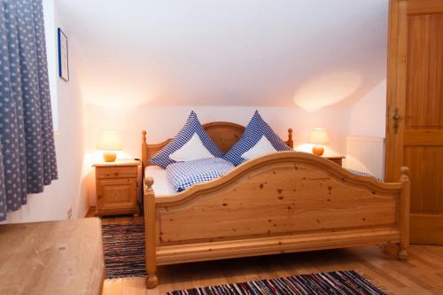 1 dormitorio con cama de madera y almohadas azules en Ferienwohnungen Kern, en Aschau im Chiemgau