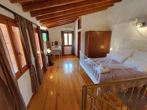 a bedroom with a large bed and a wooden floor at Nikόla's House in Mourniaí