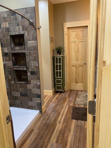 a room with a shower and a stone wall at Beech Creek Cabin, lower unit, Black Mountain in Black Mountain