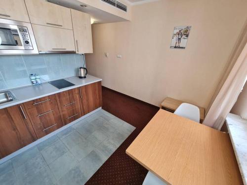 una pequeña cocina con armarios de madera y una mesa. en 10Q - Z6 Apartment 405 en Varsovia