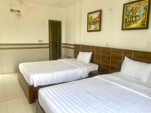 two beds in a hotel room with two beds at Shine Hotel in Hue