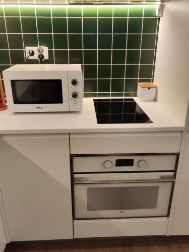 a microwave oven sitting on a counter in a kitchen at Casa Moliceiro Verde in Aveiro