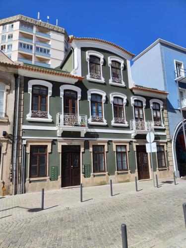 um edifício verde com janelas numa rua em Casa Moliceiro Verde em Aveiro